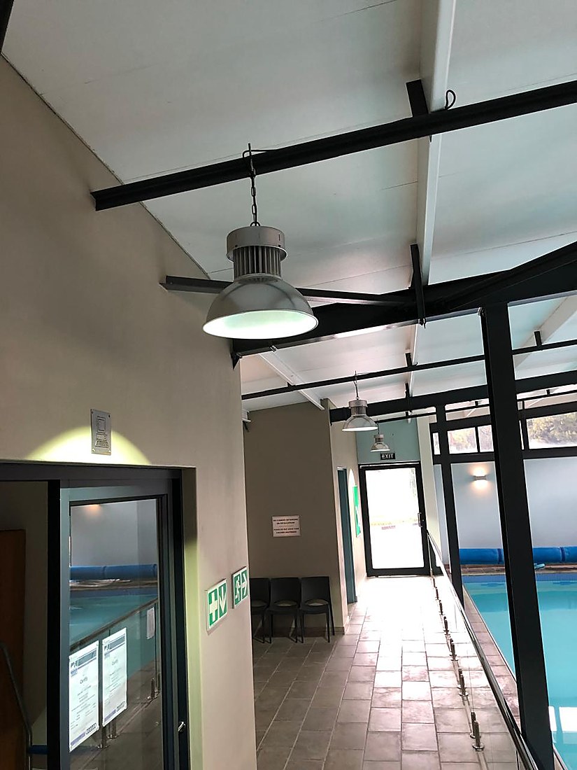 Indoor viewing corridor overlooking the second heated pool with lane ropes