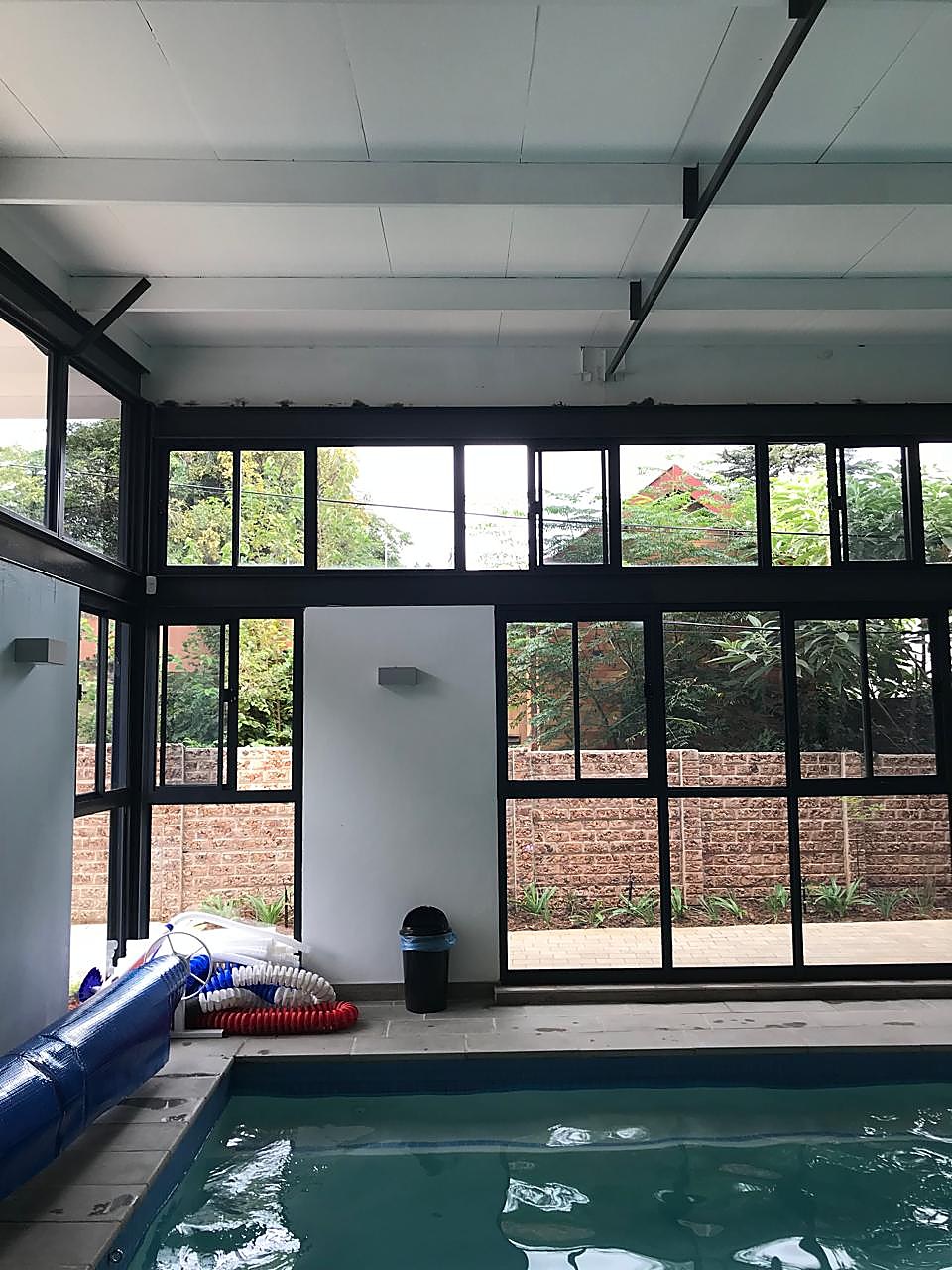 Indoor heated pool at Get Ahead Swimming with large windows overlooking the garden and boundary wall